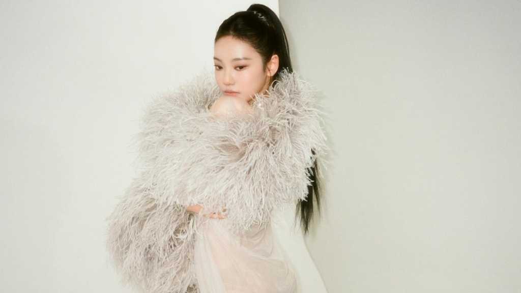 aespa's NINGNING showcases a bold sheer outfit on SNS, posing confidently in a gray fur coat, highlighting her stunning figure.