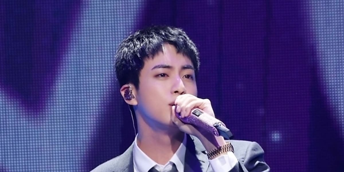 BTS Jin sparks debate after fan tries to kiss him at post-discharge hug event.
