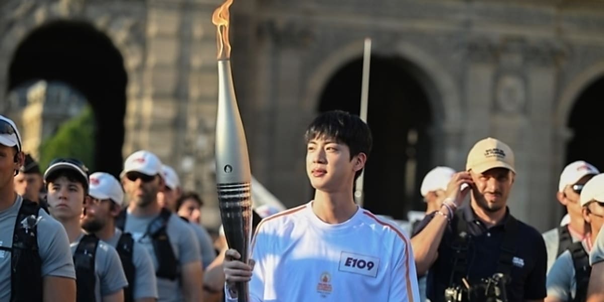 Jin of BTS runs in 2024 Paris Olympics torch relay, attracting attention from foreign media for his popularity and bright smile.