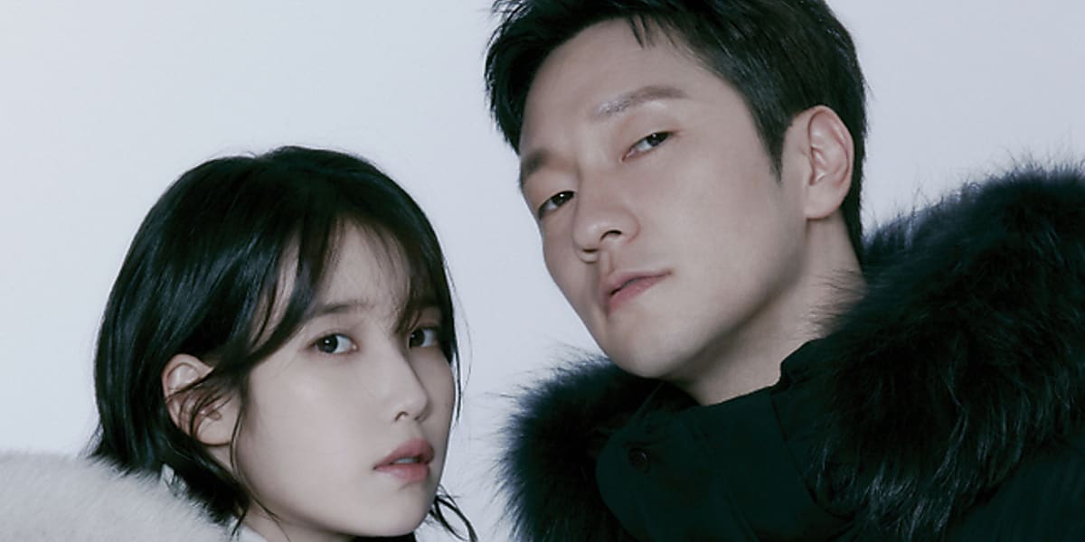 IU and Son Seok harmonized in a winter gravure, showcasing down jackets for outdoor activities in a natural atmosphere.